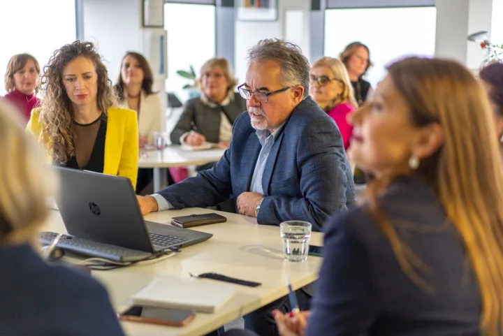 Tim MGI Dva Dukata zajedno radi za laptopom tokom sastanka